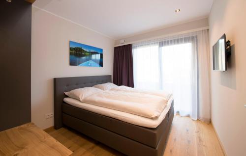a bed in a bedroom with a large window at Kitzlife Apartements in Kitzbühel