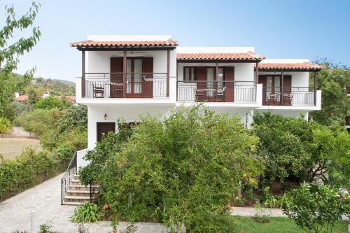 a white house with balconies on the side of it at Paris Studios & Apartment in Agia Paraskevi