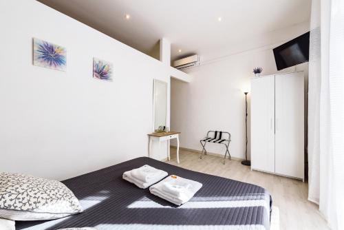 a white bedroom with a bed and a chair at Saint Peter Cozy Apartment in Rome