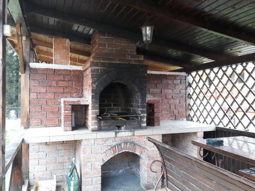 ドゥラウにあるPensiunea Lu' Movilaの屋根付きの屋外レンガ造りのオーブン