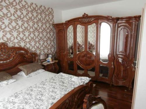 a bedroom with a large wooden bed and a window at Apartmán Deluxe in Banská Bystrica