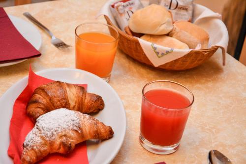 a table with a plate of pastries and a glass of orange juice at Albergo Casavecchia in Tiarno di Sopra
