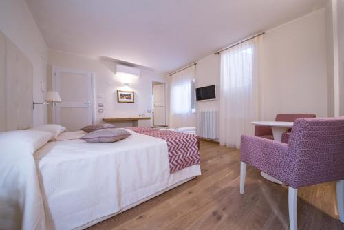 a hotel room with a bed and a table and chairs at Hotel Il Palazzo in Assisi