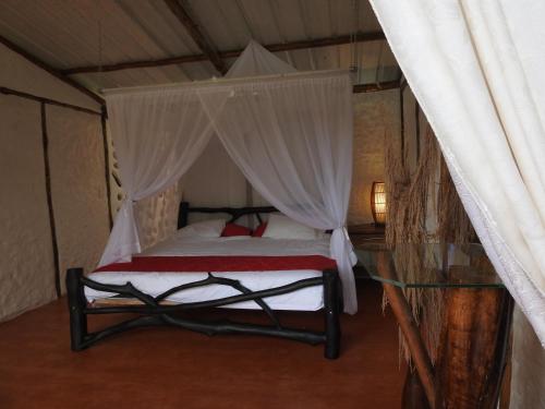 a bedroom with a canopy bed with a glass table at Posada Turistica Dantayaco in Mocoa