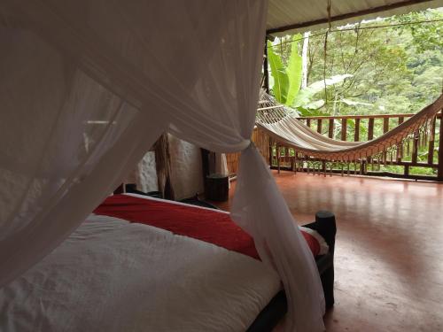 a hammock bed in a room with a balcony at Posada Turistica Dantayaco in Mocoa
