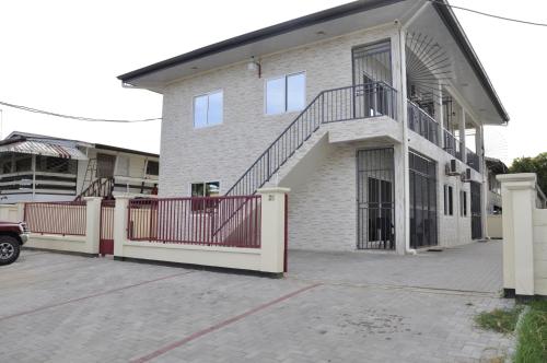 una casa con una escalera en el lateral de ella en Riando appartement Rainville en Paramaribo