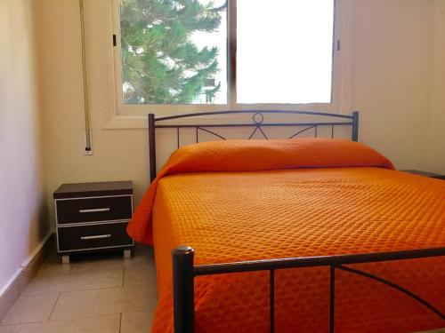 um quarto com uma cama laranja e uma janela em Andreas Apartment em Limassol