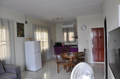 Il comprend une cuisine et une salle à manger avec une table et un réfrigérateur. dans l'établissement Riando appartement Rainville, à Paramaribo