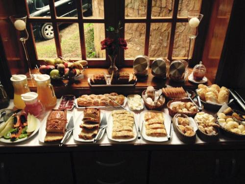 een buffet met veel verschillende soorten eten op een tafel bij Pousada do Castelo in Monte Verde