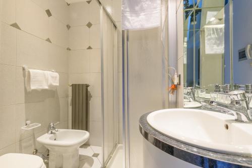 a bathroom with a sink and a toilet and a shower at Terrazza Rivola in Bergamo