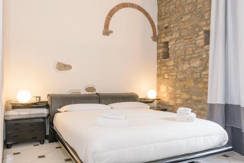 um quarto com 2 camas e uma parede de pedra em Terrazza Rivola em Bérgamo