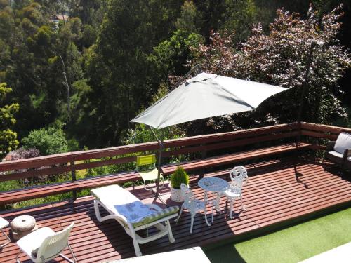 an umbrella and chairs on a wooden deck at Posada Verde Natura in Viña del Mar