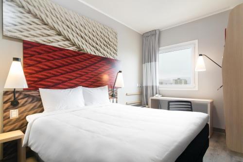 a hotel room with a large bed and a window at ibis Iquique in Iquique