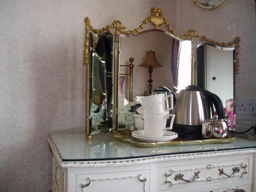 um espelho em cima de uma cómoda com uma chaleira de chá em The Villa in Robin Hoods Bay em Robin Hood's Bay