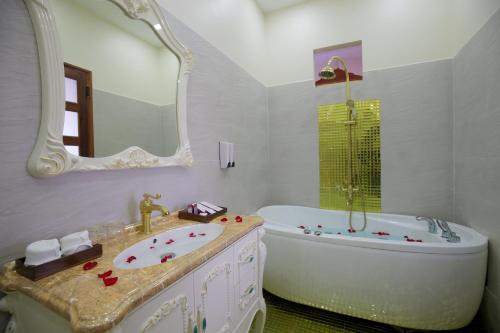 a bathroom with a tub and a sink and a bath tub at S79 Stay Sweet Home Phu Quoc in Phu Quoc