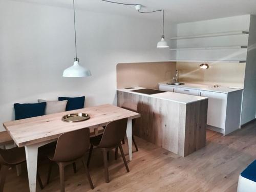 a kitchen with a wooden table and a table and chairs at See-Apartment Weiden in Weiden am See