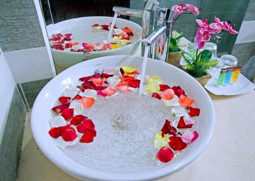 a bowl filled with water with flowers in it at Daisy Garden Villa Hoi An in Hoi An