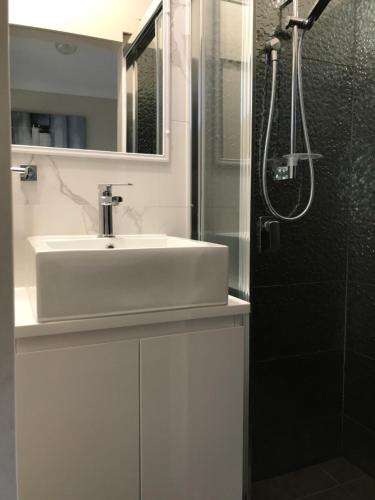 a bathroom with a sink and a shower at Mollymook Paradise Haven Motel in Mollymook