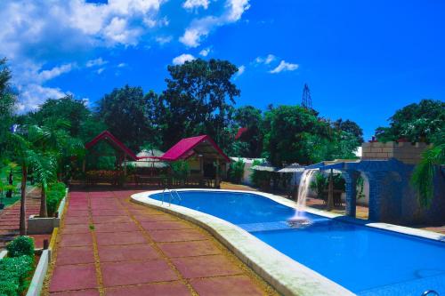 a swimming pool with a waterfall in a yard at Michelle Pension in Puerto Princesa City