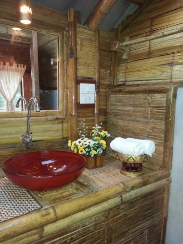 a bathroom with a red sink in a log cabin at Tulip Resort Pai in Pai