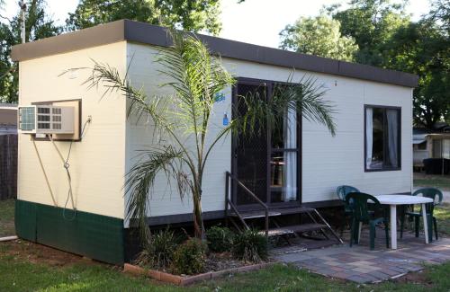 a tiny house with a table and a tree at Cohuna Waterfront Holiday Park in Cohuna