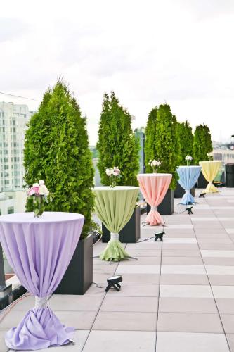 a row of tables with flowers in them on a roof at Hyatt Place Flushing/LGA Airport in Queens