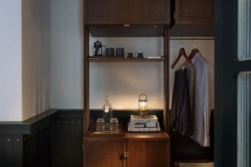 a dressing room with a shelf and a table with a lamp at The Fleming Hong Kong in Hong Kong