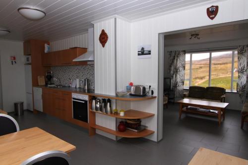 a kitchen and living room with a table and chairs at Guesthouse Steindórsstadir, West Iceland in Reykholt