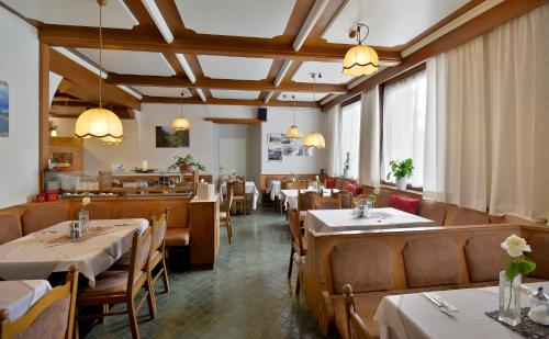uma sala de jantar com mesas e cadeiras num restaurante em Hotel Gisela em Kufstein