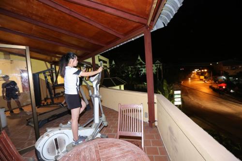 a woman riding a scooter on a balcony at night at Charming Lao Hotel in Ban Chéng