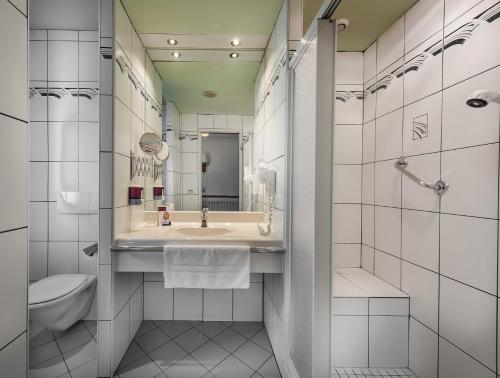 uma casa de banho com um lavatório e um WC em Johannesbad Hotel Palace - Kinder bis 11 kostenfrei em Bad Hofgastein