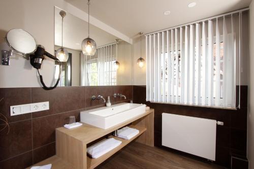 ein Bad mit einem Waschbecken und einem Spiegel in der Unterkunft Hotel Restaurant Reichsadler in Buchen