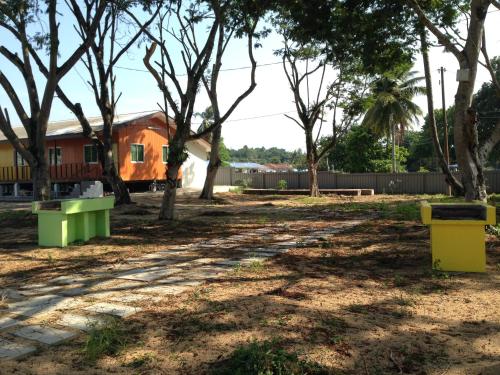 a house in the middle of a yard with trees at First Guest House in Kuantan