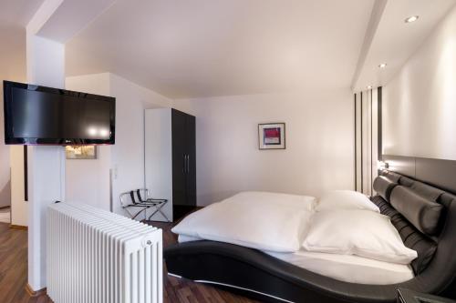 a bedroom with a bed and a flat screen tv at Turmhotel Rhein-Main in Dreieich