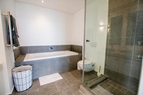 a bathroom with a tub and a toilet and a shower at 810 Marina Village in Langebaan