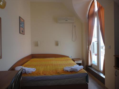 a bedroom with a bed and a window at Barex Family Hotel in Sozopol