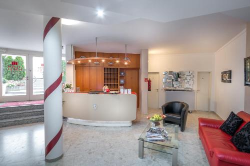 a living room with a red couch and a kitchen at Turmhotel Rhein-Main in Dreieich