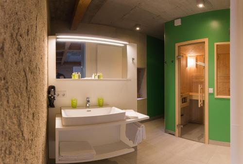 a bathroom with a white sink and green walls at DIE KRONE - Hotel Garni in Kirchzarten