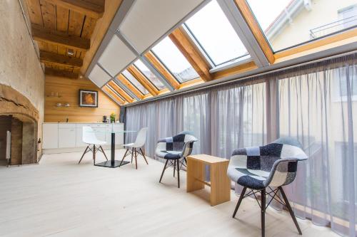 a room with chairs, tables, and a large window at DIE KRONE - Hotel Garni in Kirchzarten