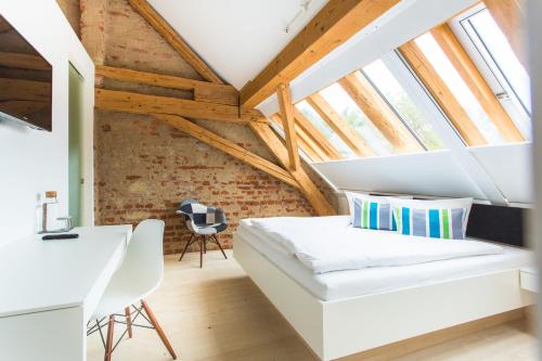 a bedroom with a bed and a desk in a attic at DIE KRONE - Hotel Garni in Kirchzarten