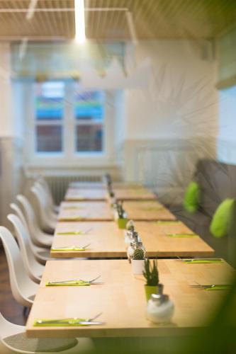 a long long table with chairs and plants on it at DIE KRONE - Hotel Garni in Kirchzarten