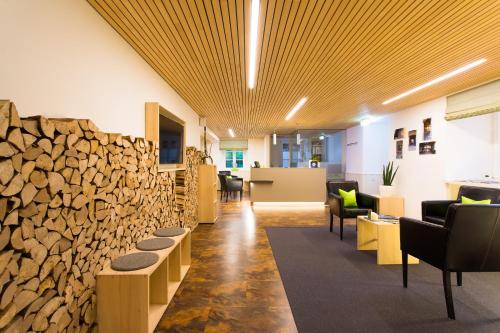 a lobby with a stone wall and a pile of wood at DIE KRONE - Hotel Garni in Kirchzarten