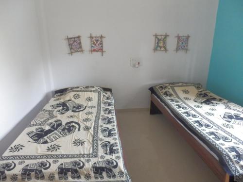 two twin beds in a room with stained glass windows at Senamura Yoga Ashram Guesthouse in Bodh Gaya