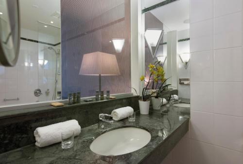 a bathroom with a sink and a mirror at Excelsior Hotel Nürnberg Fürth, a member of Radisson Individuals in Fürth