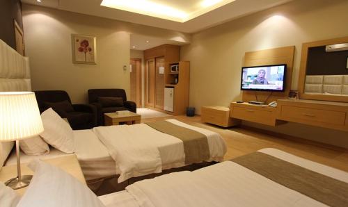 a hotel room with two beds and a flat screen tv at Meera Suites in Riyadh