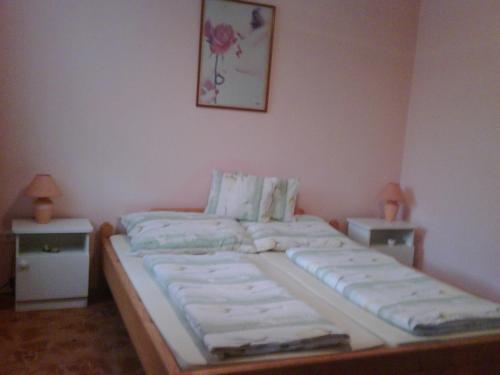 a bedroom with a large bed with two night stands at Relax Apartmanok in Zalakaros