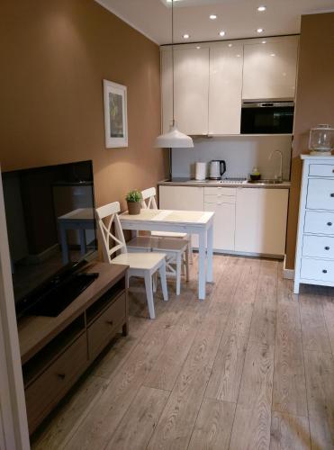 a kitchen with a white table and chairs in a room at Kamienica Poznańska 7 in Bydgoszcz