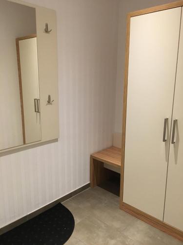 a dressing room with a mirror and a cabinet at Heeren's Hotel Garni in Bensersiel
