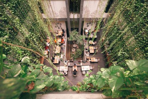 a group of people sitting in a garden at Grandmas Plus Hotel Legian in Legian