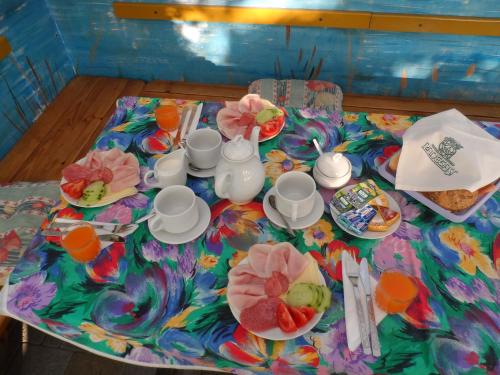 a table with cups and plates of food on it at Penzion Kapitan in Jindrichuv Hradec